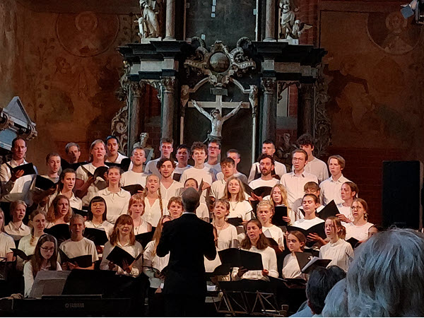 Auf dem Bild sind Sängerinnen, Sänger der St.-Jonannis-Kirche während eines Konzertes in einer Kirche zu sehen.
